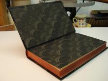 Dance of Death, bound in half leather, black morocco with paste paper sides and end papers.